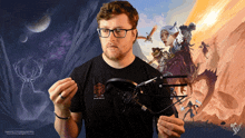 a man wearing glasses is holding a microphone in front of a painting of a deer