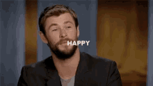 a man with a beard is smiling with the word happy written above him .