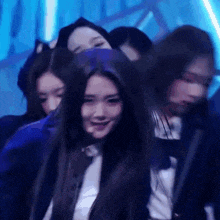 a group of women are dancing in a dark room and one of them is smiling .
