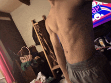 a man without a shirt is standing in front of a tv screen that says ap on it