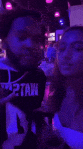 a blurry picture of a woman sitting in a room with purple lights