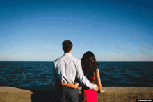 a man and a woman looking at the ocean with jl wedding.com written on the bottom right