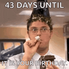 a man wearing a party hat is eating a piece of cake