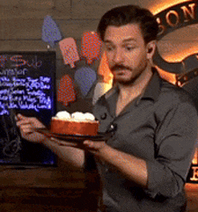 a man is holding a plate of food in front of a sign that says " sub "