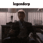 a man in a suit sits in a chair with the word legenderp on the bottom