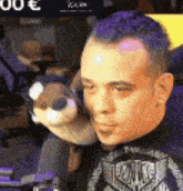 a man with purple hair is holding a stuffed animal in his hands