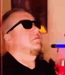 a man wearing sunglasses is sitting in a chair .