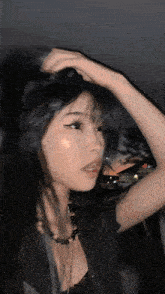 a girl with long black hair is wearing a black top and a black necklace