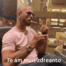 a man wearing sunglasses is smoking a cigar and says te am muit zdreanto