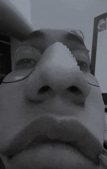 a black and white photo of a person 's face with glasses