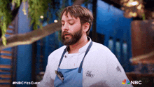 a man with a beard wearing a chef uniform