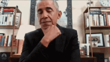 a man in a suit is sitting at a desk with his eyes closed