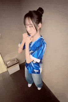 a girl wearing a blue and white jersey with the letter u on the front