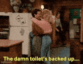 a man and woman hugging in a kitchen with the words " the damn toilet 's backed up " above them