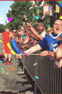 a crowd of people watching a parade with a sign that says lgbtq