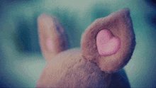 a close up of a stuffed animal 's ear with a pink heart on it