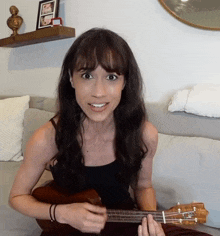 a woman sitting on a couch with a guitar