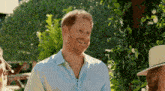 a man with a beard is smiling while wearing a blue shirt