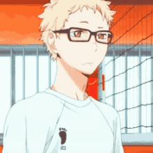 a boy wearing glasses and a white shirt with ics on it