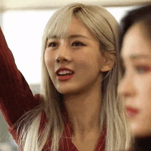 a close up of a woman with blonde hair and red lips .