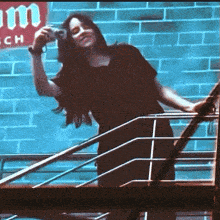 a woman taking a picture with a camera in front of a sign that says ' mm '