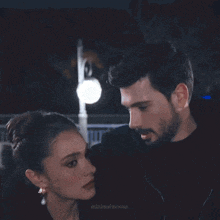 a man and a woman are hugging and kissing in a dark room .