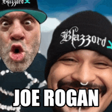 two men are posing for a picture and one of them has the name joe rogan on his hat