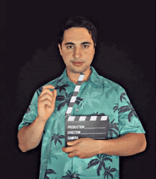 a man holding a clapper board with the words production director camera on it