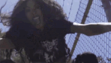 a woman wearing a black shirt with a skull on it is jumping in the air