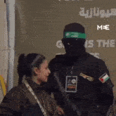 a man wearing a green headband is standing next to a girl