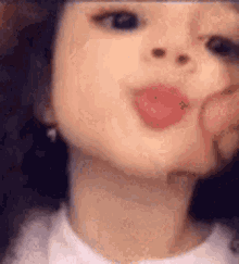 a close up of a woman 's face with a person 's hand on her face .