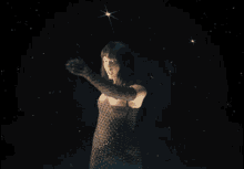 a woman in a black top with studded sleeves is dancing