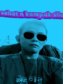 a man wearing sunglasses and a t-shirt that says ' sehatn kompak sip ' on it