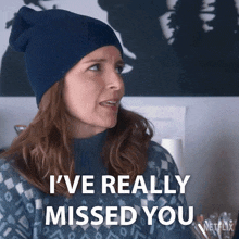 a woman wearing a blue hat and sweater is saying i 've really missed you
