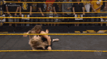 two women are wrestling in a ring with nxt live on the bottom