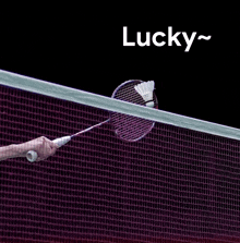 a person is holding a badminton racket in front of a net and the word lucky is above it