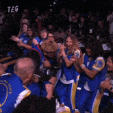a group of people are applauding a golden state warriors basketball team