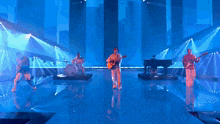 a man is playing a guitar on a stage in front of a drum set .