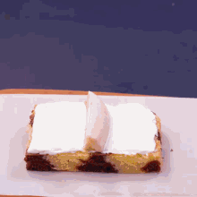 a piece of cake with white frosting and a banana slice on top