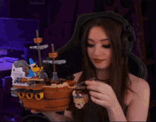 a woman wearing headphones is holding a toy ship in her hand