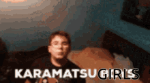a blurry picture of a person with the words karamatsu girls written in white