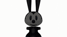 a black rabbit is sitting on a white surface .