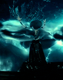 a woman in a black dress is surrounded by lightning in a dark room