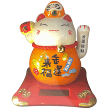 a statue of a cat with chinese writing on it sits on a red base