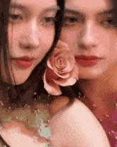 two women are posing for a picture and one has a pink rose in her hair