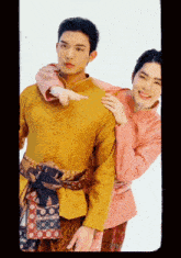 a man in a yellow shirt and a woman in a pink shirt are posing for a photo