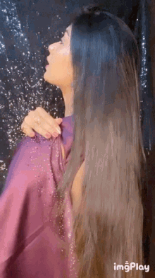a woman in a purple dress has a gif of her hair