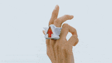 a person in a blue jacket is holding a piece of crumpled paper in their hand