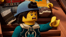 a lego character wearing a blue hat and a blue sweatshirt with the letter m on it