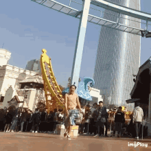 a man without a shirt is running in front of a roller coaster